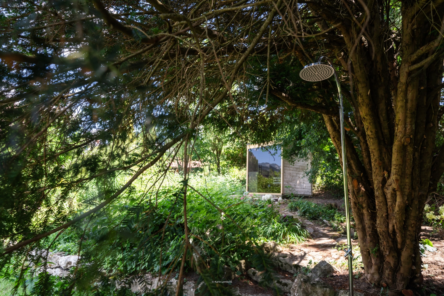 Die Sauna inmitten des Gartens. Zus&auml;tzlich ist die Garten-Dusche zu sehen.